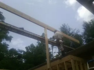Carpenter setting a ridge beam over a new addition frame — Ice Dam Removal by Roofing Brothers in North Lima