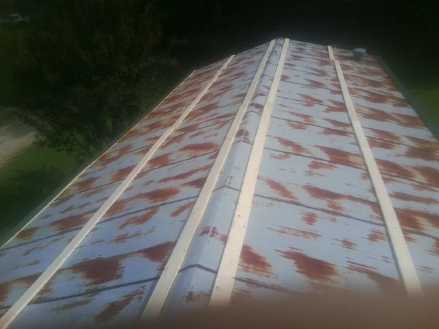 Rusted metal roof panels with new wood purlins before replacement — Storm Damage Roof Repair in North Lima by Roofing Brothers