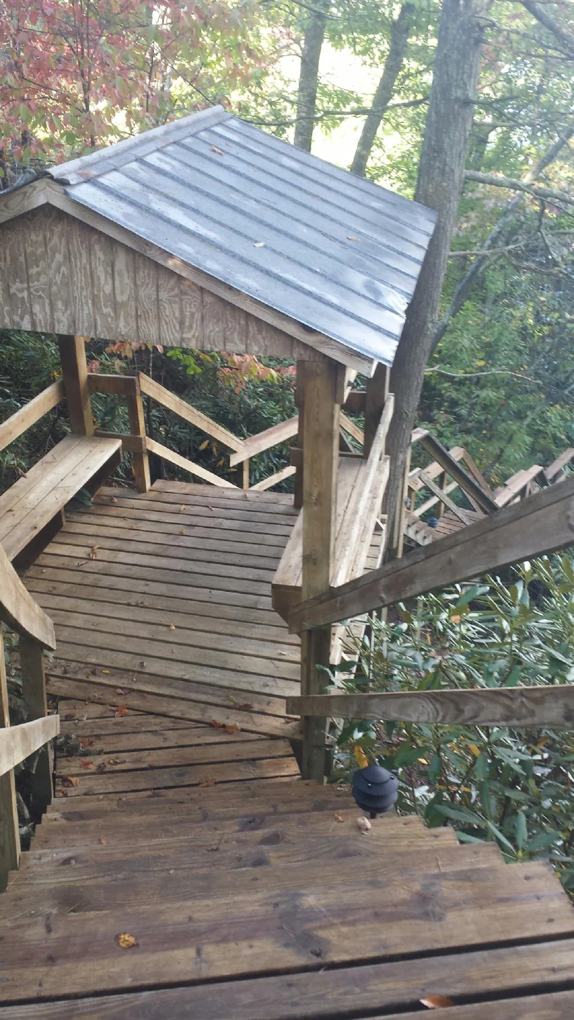Metal roofed shelter over wooden steps on a wooded walkway — Skylight Repair & Installation work by our crew in North Lima