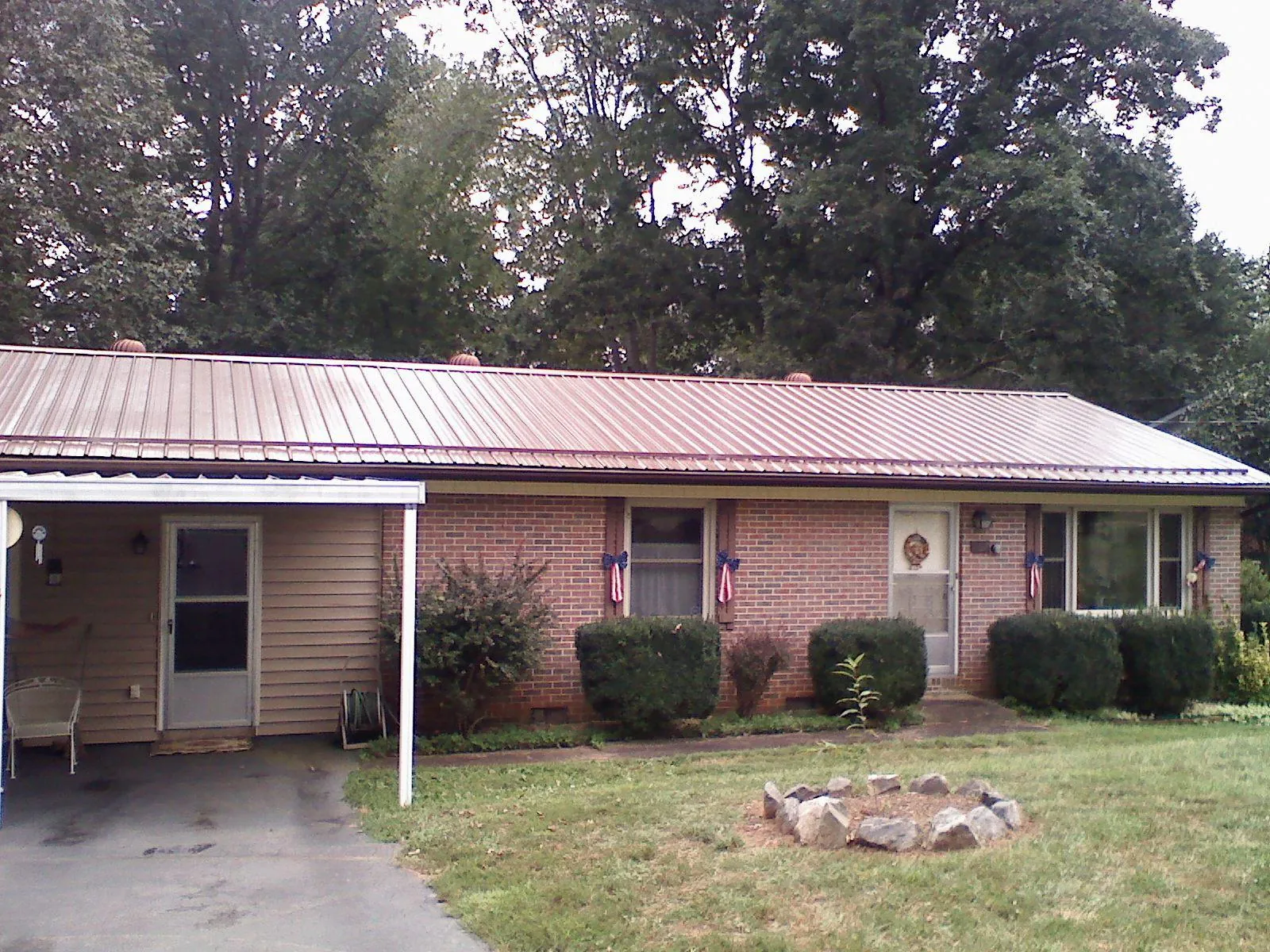 Bronze metal roof and carport on a brick ranch home — Roof Repair work by our crew in North Lima