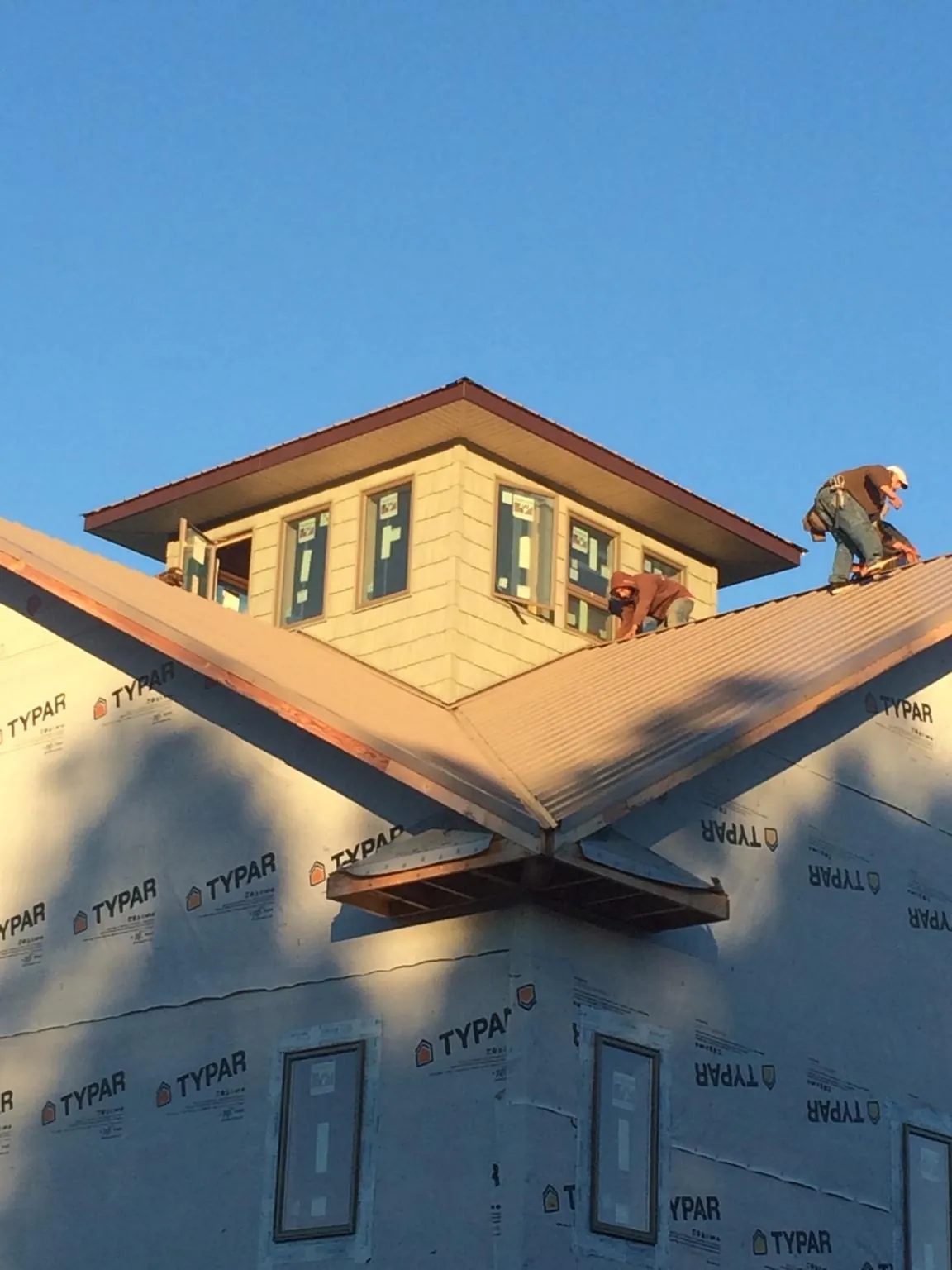 Roofers working around a rooftop cupola on a new metal roof at sunset — Roof Waterproofing in North Lima by Roofing Brothers